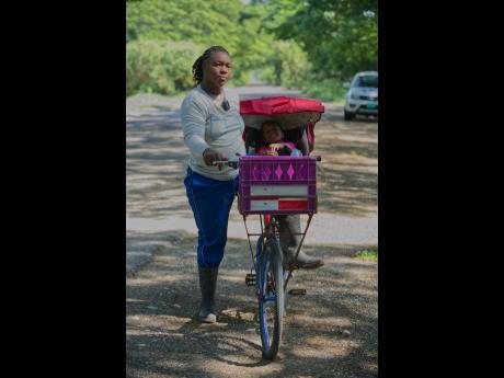 Farmer Nicole McFarlane and her niece Talliah McFarlane making their way across the Lakes Pen main road in St Catherine.