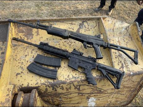 An AK-47 and an M16 rifle, two of the 10 guns found at the Stadium East field in St Andrew. 