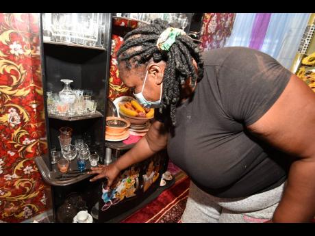 Jacqueline Davis shows the amount of dust that has ended up on her furniture, a negative side effect of the road construction.