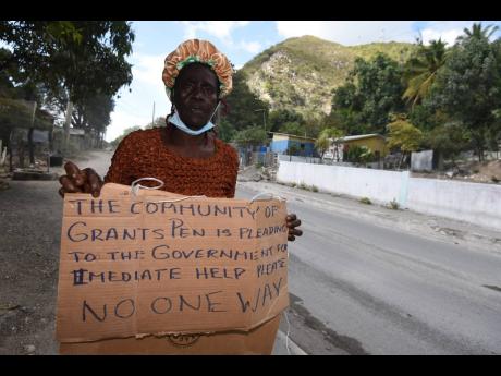 Beverly Morgan protests along the Grants Pen main road in St Thomas yesterday.