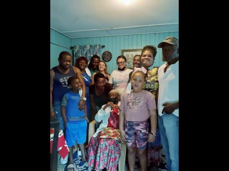 Centenarian Elsie Samuels is surrounded by a small group of family and friends.