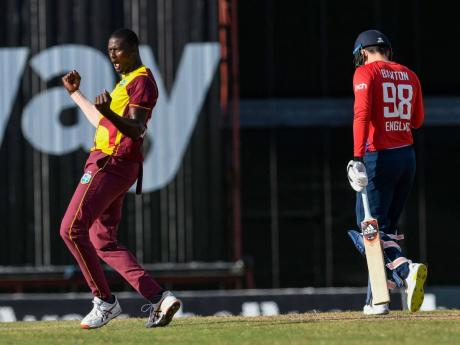 Jason Holder (left) celebrates a wicket against England during the fourth T20 between the teams at the Kensington Oval in Barbados on Saturday.