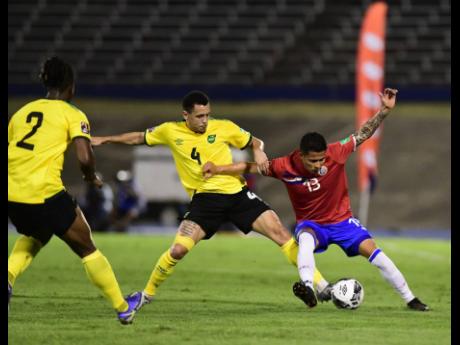 Jamaica’s Ravel Morrison (centre) challenges Costa Rica’s Gerson Torres (right) for possession, while Reggae Boy Gregory Leigh monitors the action in the World Cup Qualifier at the National Stadium on Wednesday night. Costa Rica won 1-0.