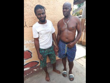 Kemar Campbell (left) bravely assisted Ainsley Scott, a Jamaica Public Service Company contract worker, who was electrocuted by a power line in Arnett Gardens last week. Scott succumbed to his injuries on Monday. At right is Lenford Thomas, a community member.