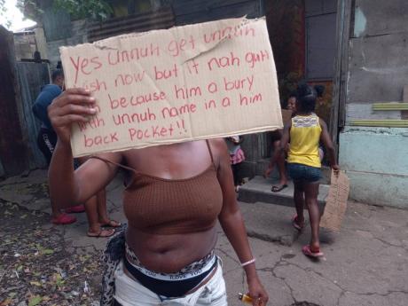 A resident of Adelaide Street protests the killing of Javion Smith by police. Residents claim that Smith was killed in cold blood.