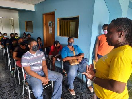 President of the Kiwanis Club of North Spanish Town, Simone Allen Archer (right), addresses residents.