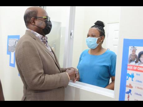 Minister of Tourism and Member of Parliament for St James East Central, Edmund Bartlett (left), engages with community health aide at the newly rehabilitated Barrett Town Health Centre, Simone Shaw Dwyer,  during a ceremony for the official handover of the facility.