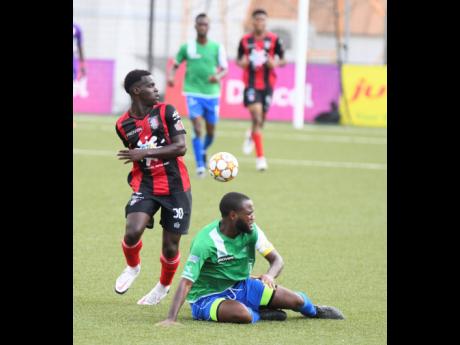 Arnett Gardens’ Marlon Allen looks at the ball while Montego Bay United’s Giovannie Reid sits on the ground during their Jamaica Premier League football match at the UWI-JFF Captain Horace Burrell Centre of Execellence last Saturday. Arnett won 3-1.