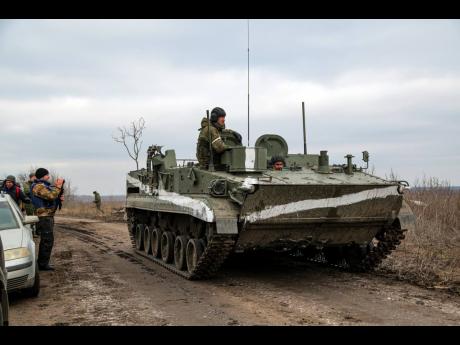 A cameraman films as an armoured vehicle rolls outside Mykolaivka, Donetsk region, the territory controlled by pro-Russian militants, eastern Ukraine on Sunday. Fighting also raged in two eastern territories controlled by pro-Russia separatists.