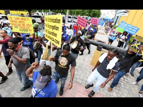 Persons participate in the United Independents’ Congress-led protests in downtown Kingston last September.