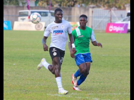 Cavalier’s Collin Anderson (left) is closely marshalled by Montego Bay United’s Phillip Eubanks during their Jamaica Premier League encounter at the Drax Hall Sports Complex in St Ann yesterday.