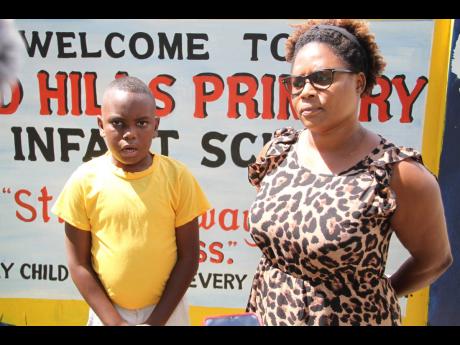 Adjani Reid (left) was Xavier AJ Phillips’ best friend. Here he stands with Tracy-Ann Francis, teacher at  Red Hills Primary and Infant School.