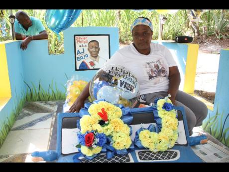 Joan Brown sits on the grave of her grandson,  Xavier ‘AJ’ Phillips.
 