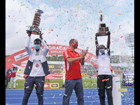 The captains of the winning schools,  J’Voughnn Blake (left)  of Jamaica College  and Edwin Allen High’s Ackelia Smith celebrate with  GraceKennedy’s  CEO Don Wehby at the National Stadium after topping the 2021 ISSA-GraceKennedy Boys and Girls’ Athletics Championships.