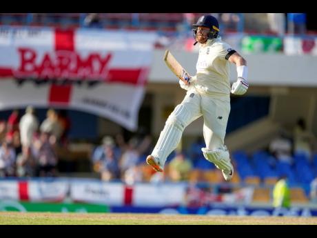 England’s Jonathan Bairstow celebrates after scoring a century against West Indies during day one of their first cricket Test match at the Sir Vivian Richards Cricket Ground in North Sound, Antigua and Barbuda yesterday.