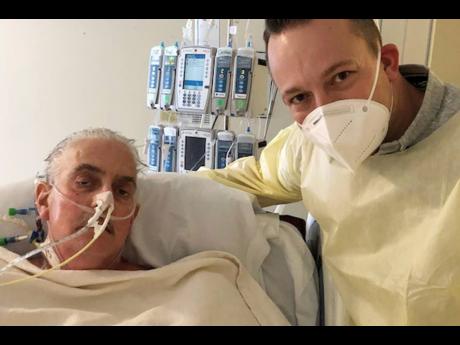 David Bennett Jr (right), stands next to his father’s hospital bed, five days after doctors transplanted a pig heart into Bennett Sr, in a last-ditch effort to save his life. 