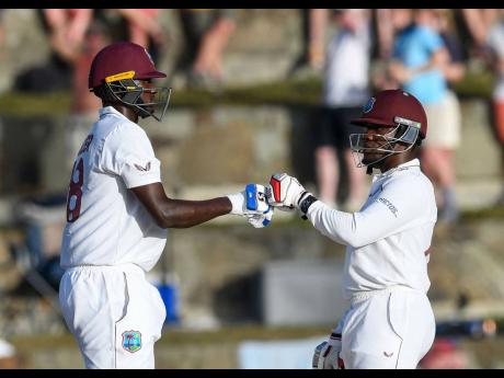 West Indies batsmen Jason Holder (left) and Nkrumah Bonner during their partnership against England in their first Test match, played at the Sir Vivian Richards Stadium in North Sound, Antigua and Barbuda, yesterday.
