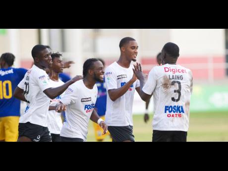Cavalier’s Christopher Pearson (second right) celebrates his goal with Jeovanni Laing (right) and other teammates during their Jamaica Premier League game against Molynes United at Sabina Park in Kingston yesterday.