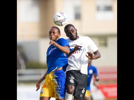 Molynes United’s Carrick Stewart (left) goes up for a header with Cavalier’s Nickache Murray during their Jamaica Premier League match at Sabina Park in Kingston on Monday.
