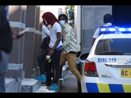 Alleged members of the notorious One Don Gang are escorted to the Supreme Court in downtown Kingston.