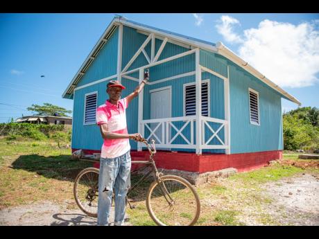 Vincent Richards points to his new home in Spicy Hill, Trelawny. 