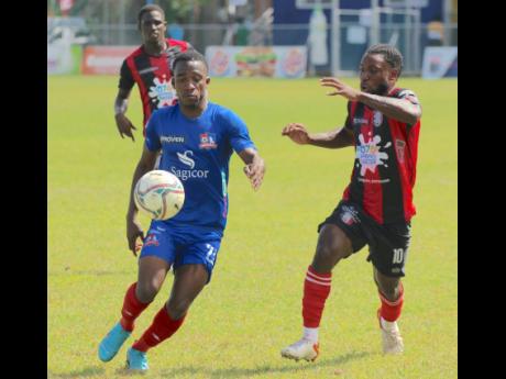 Nickoy Christian (left) of Dunbeholden battles for possession with Arnett Gardens’ Ajuma Johnson in their Jamaica Premier League encounter at the Drax Hall Sports Complex in St Ann on Monday, February 28.
