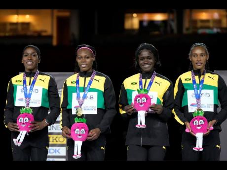 Credit: AP Jamaica’s Women’s 4x400m relay team of (from left) Janieve Russell, Roneisha McGregor, Junelle Bromfield, and Stephenie Ann McPherson pose with their gold medal at the World Athletics Indoor Championships in Belgrade, Serbia, yesterday.