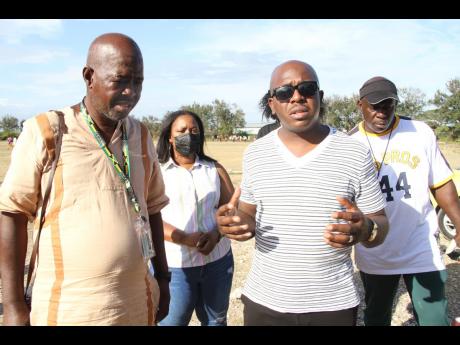 Clarendon South East Member of Parliament Pearnel Charles Jr (right, foreground) in discussion with Lionel Town Sports Academy founder David Dixon in the presence of community leaders Donna Dobson (second left) and Lincoln Turner during a football match. The game, part of a peace initiative in the community, was played at Pawsey Park in Lionel Town, Clarendon, on Saturday.