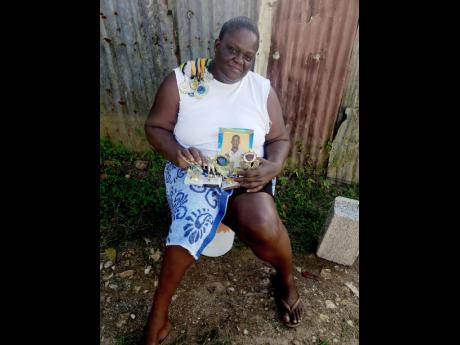 Natasha Roach has promised not to part with medals won by her son, Khamal Hall, the William Knibb High School student who was stabbed to death at his school on Monday.