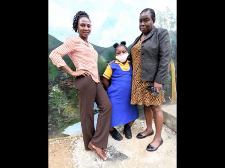 Stony Hill Primary School student Abriella Weasley is flanked by her teachers Kimarla Johnson-Fagon (left)  and Maureen Pinnock-Forbes.
