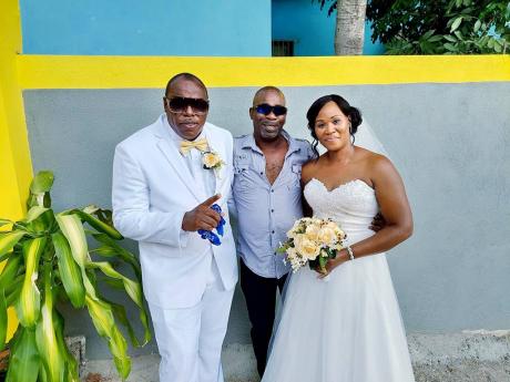 Lovebirds Kenute Williams Sr. (left) and his beautiful bride Carroline Robinson share a moment with Roger Marshall (centre), the man who attempted to save their son’s life after he was shot last Wednesday.