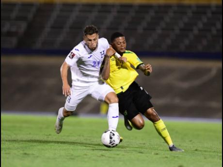 Leon Bailey (right), who scored Jamaica’s first goal, tussles with Honduras’ Raúl Santos for possession of the ball.