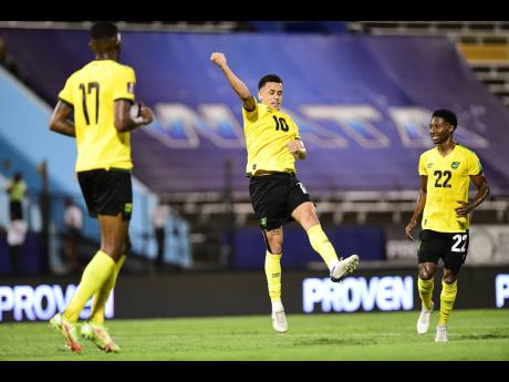 Jamaica’s Ravel Morrison (centre) celebrates his winning goal against Honduras with teammates Devon Williams (right) and Damion Lowe during their FIFA World Cup qualifying football match at the National Stadium last night.
