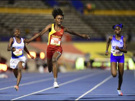 Wolmer’s Natrece East (centre) celebrates at the finish line while winning the Class Four Girls 100m final ahead of St Catherine High’s Ackeelah White (right) and Immaculate Conception’s Kedoya Lindo at the National Stadium last night.