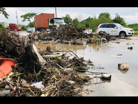 Credit: Shanel Lemmie Motorists try to navigate a flooded and near impassable Chesterfield Drive on Tuesday amid heavy rainfall that affected sections of the island. The major thoroughfare that connects Marcus Garvey Drive to Spanish Town Road is consistently affected by flooding due to blocked drains.