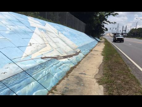 In this file photo, traffic passes a mural of the slave ship Clotilda along Africatown Boulevard, in Mobile, Atlanta.