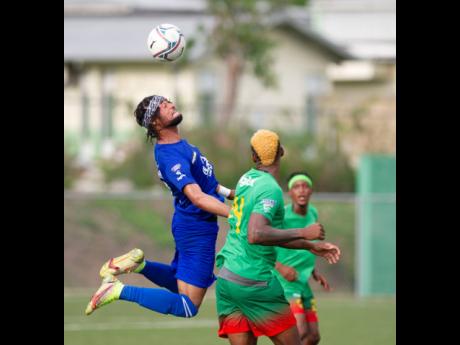 Portmore United defender Chevoy Watkin (left) leaps to head the ball away from Humble Lion player Andre Clennon during their Jamaica Premier League game at the UWI-JFF Captain Horace Burrell Centre of Excellence yesterday. Humble Lion won 1-0.