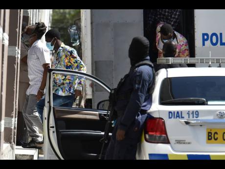Alleged members of the Clansman-One Don gang arrive at the Home Circuit Court in downtown Kingston on Monday as the trial resumed after a seven-week break.