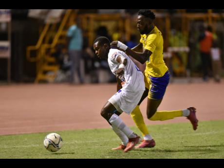Mount Pleasant’s Donovan Segree (left) is challenged by Molynes United’s Jermy Nelson during their Jamaica Premier League match at Stadium East in St Andrew last night.