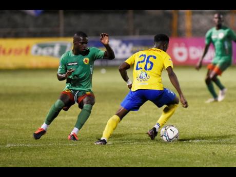 Lorenzo Lewin (left) of Humble Lion FC tracks the movement of Jamone Shepherd of Harbour View FC during their Jamaica Premier League game at the Anthony Spaulding Sports Complex in Kingston last night.