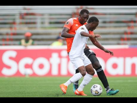 Dwayne Atkinson (right) of Cavalier attempts to get past Dairin Gonzalez of Cibao FC during the Flow Concacaf Caribbean Club Championship match held at the Estadio Cibao stadium in Santiago de los Caballeros, Dominican Republic yesterday.