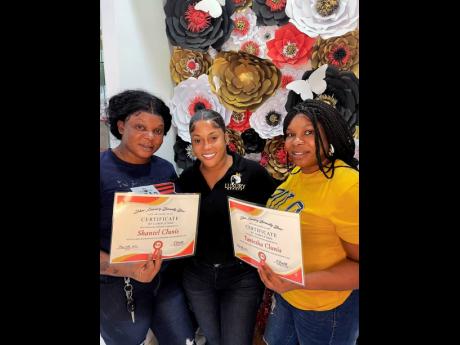 Dancer-turned-hairstylist and salon owner Sher Luxury Doll (centre) stands with two of the participants, Shantel and Taniesha Clunis, who successfully completed the recent Lace Meltdown workshop.