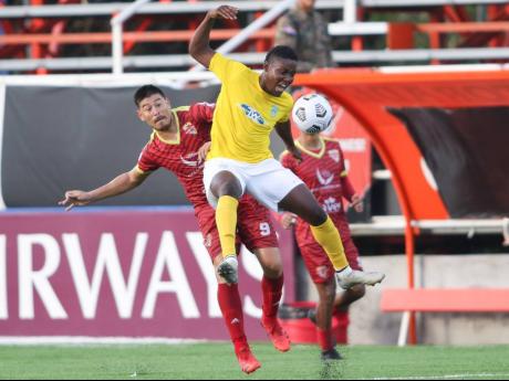 Shequeil Bradford  (front) of Waterhouse FC  is tackled by Mauro Gomez of Vega Real during the third place match in the FLOW Concacaf Caribbean Club Championship held at the Estadio Cibao stadium in Santiago de los Caballeros, Dominican Republic on Sunday.