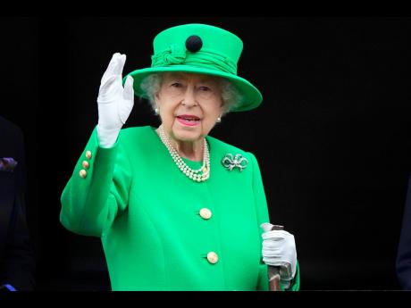 Credit: Frank Augstein Britain’s Queen Elizabeth II waves to the crowd during the Platinum Jubilee Pageant at Buckingham Palace in London, Sunday.