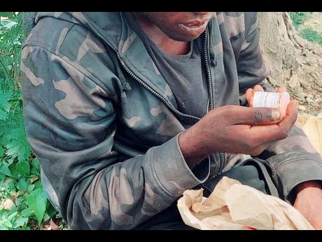 Paul looks at a bottle containing medication that he was given at hospital after he was allegedly sexually assaulted by five men.