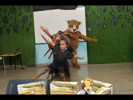 Students of the Union Gardens Infant School and teacher Nyoka McKoy (dressed as a mascot), perform an item at the launch of the ‘Little Jamaican Early Childhood Learning Kit’ held recently at the Kingston-based school.
