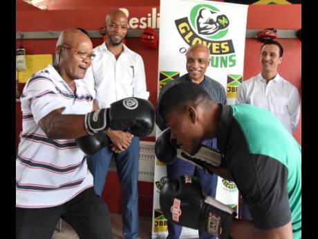 Suga Knockout Boxing Gym President Lindel ‘Suga’ Wallace (left) and amateur boxer Jerome Ennis (second right) show off their boxing skills to Jamaica Boxing Board President Stephen Jones (second left), Jamaica Olympic Association President Christopher Samuda (centre) and Suga Knockout Boxing Gym Vice President Felipe Sanchez at the Launch of Fight Night on Olympic Way at Cling Cling Oval in Olympic Gardens, St Andrew yesterday.