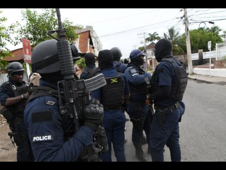 Police personnel in Spanish Town, St Catherine on Tuesday following a flare-up of violence.