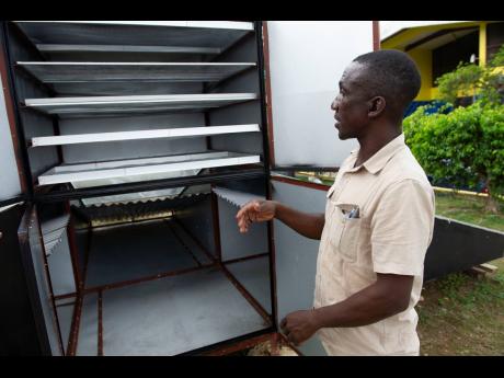 Robin Rhoden, maintanance supervisor at Sydney Pagon STEM Academy in St Elizabeth, explains how the solar dehydrator works.