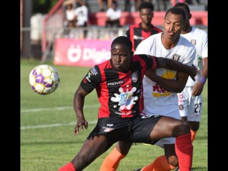 Arnett Gardens’ Fabian Reid (left) gets between Tivoli Gardens’ Odean Pennycooke and the ball during their Jamaica Premier League game at the Anthony Spaulding Sports Complex in Kingston on Sunday, June 5.